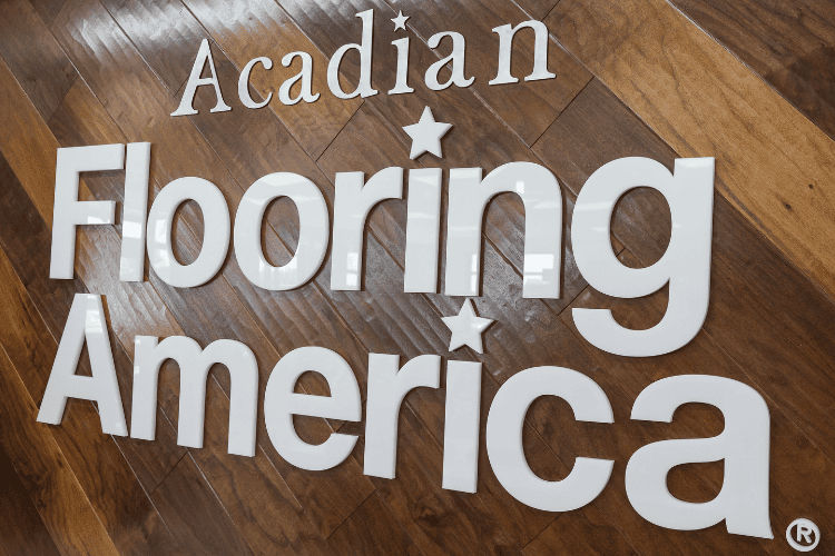 Acadian Flooring America sign with hardwood flooring background