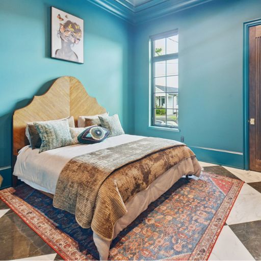 colorful patterned area rugs in a blue bedroom