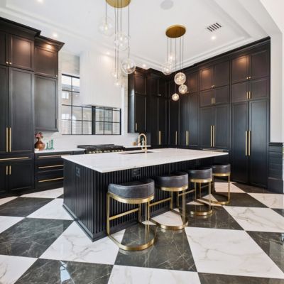 checkered tile floors in a large kitchen with island and black cabinets