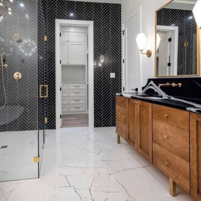 bright white stone tile floors and black tile accent wall in luxury bathroom